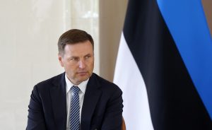 Igaunijas aizsardzības ministrs Hanno Pevkurs oficiālā tikšanās laikā uz Igaunijas valsts karoga fona.