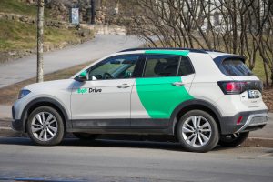 “Bolt Drive” koplietošanas automašīna novietota stāvēšanai pilsētvidē.