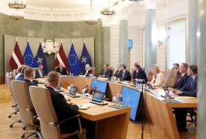 Ministru kabineta sēde valdības ēkā, kur pie viena galda pulcējušies ministri un valdības pārstāvji.