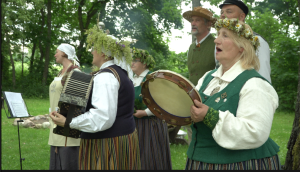 Folkloras kopa tautastērpos dzied Līgo svētku un Jāņu tradīciju pasākumā brīvā dabā.