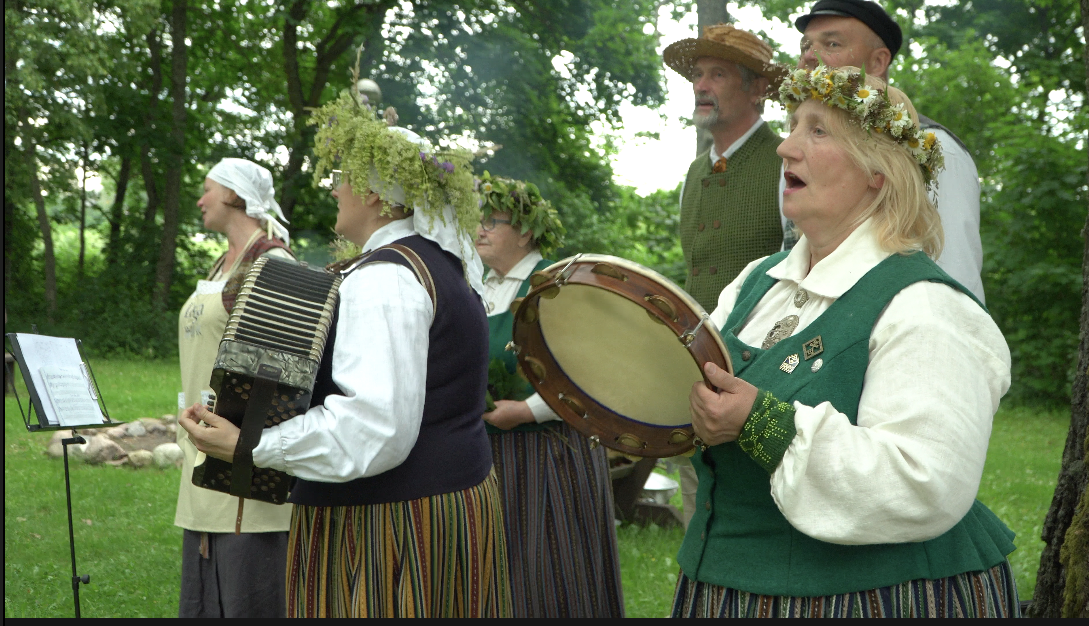 Folkloras kopa tautastērpos dzied Līgo svētku un Jāņu tradīciju pasākumā brīvā dabā.