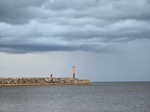 Skultes ostas ziemeļu mols zem tumšiem negaisa mākoņiem.