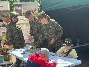 Latvijas Valsts robežsardzes pārstāvji iepazīstina bērnus ar robežsarga profesiju izglītojošā pasākumā.