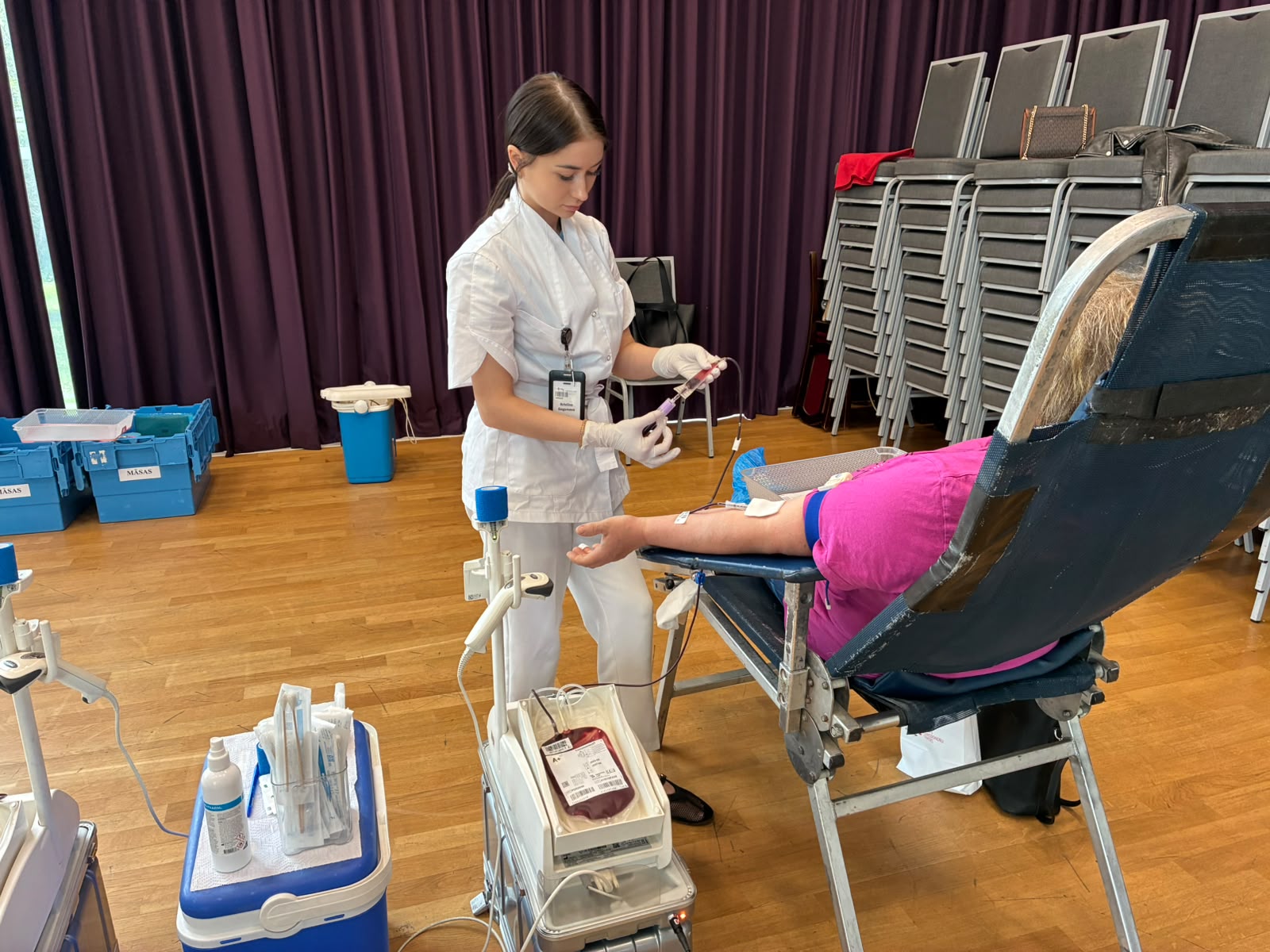 Medicīnas darbiniece donoru dienā sagatavo asins ziedošanas procedūru.