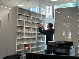 Jaunietis Rēzeknes slimnīcā kārto dokumentus arhīvā vasaras darba laikā.