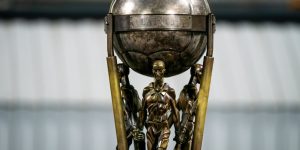 Baltijas kausa trofejas fragments ar bronzas figūrām un futbola bumbu augšdaļā.