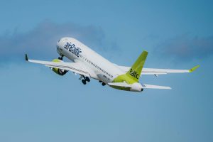 airBaltic pasažieru lidmašīna paceļas lidojumā zilās debesīs.