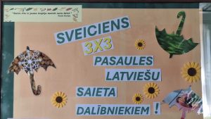 Uz informatīvā stenda izvietots sveiciens "3x3" pasaules latviešu saieta dalībniekiem Bebrenē.
