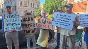 Protestētāji pie Izglītības un zinātnes ministrijas ar plakātiem pret Murjāņu Sporta ģimnāzijas Jūrmalas filiāles slēgšanu.