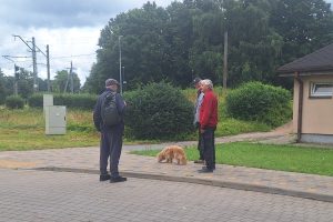 Vīrietis pastaigājas ar suni pie dzelzceļa stacijas Ādažu novadā.