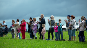 Skatītāji vēro un aplaudē rikšotāju sacensību dalībniekiem Pušmucovas trasē.