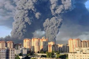 Virs daudzstāvu dzīvojamajām ēkām Kotovskā Tambovas apgabalā Krievijā paceļas milzīgs tumšu dūmu mākonis pēc sprādziena vai ugunsgrēka.
