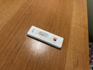 Ātrais C hepatīta tests ar asins paraugu uz galda.