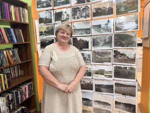 Klintaines bibliotēkas vadītāja Alita Kluša pie vēsturisko fotogrāfiju izstādes.
