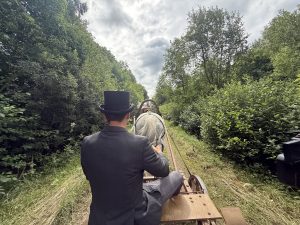 Sandis Ģērmanis vada zirga pajūgu pa meža ceļu Puikulē.