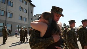 VAD karavīrs Ādažu militārajā bāzē apskauj tuvinieci vecāku dienā.