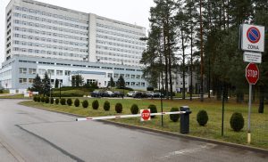 Daugavpils reģionālās slimnīcas galvenā ēka ar piebraucamo ceļu un stāvlaukumu.