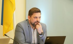 Ogres novada domes priekšsēdētājs Andris Krauja domes sēdē pie mikrofona un datora.