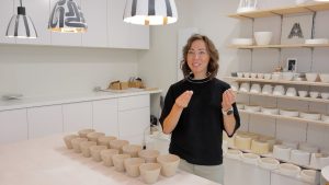 Zīmola “Cerannic” radītāja Annija Kanska porcelāna darbnīcā pie galda ar traukiem.