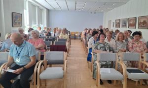 Senioru skolu pārstāvji un konferences dalībnieki pulcējušies konferenču zālē pirms pasākuma sākuma.