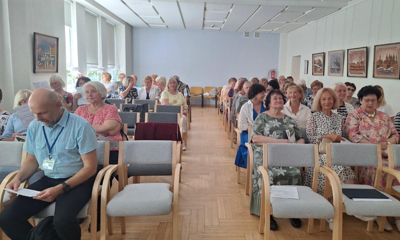 Senioru skolu pārstāvji un konferences dalībnieki pulcējušies konferenču zālē pirms pasākuma sākuma.