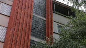 Daudzdzīvokļu mājas fasāde ar redzamām nolietojuma pazīmēm pirms renovācijas.