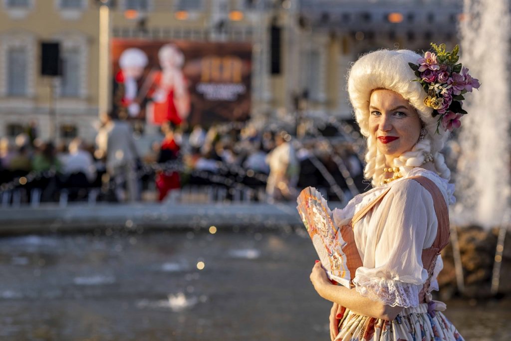 Sieviete vēsturiskā tērpā Senās mūzikas festivālā Rundāles pils dārzā.