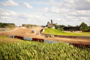 Sacensību automašīnas putekļainā līkumā Bauskas "Mūsa Raceland" trasē Latvijas autokrosa čempionāta posmā.