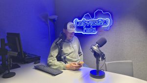 Radio "Latviešu hiti" dīdžejs strādā radio studijā pie mikrofona.