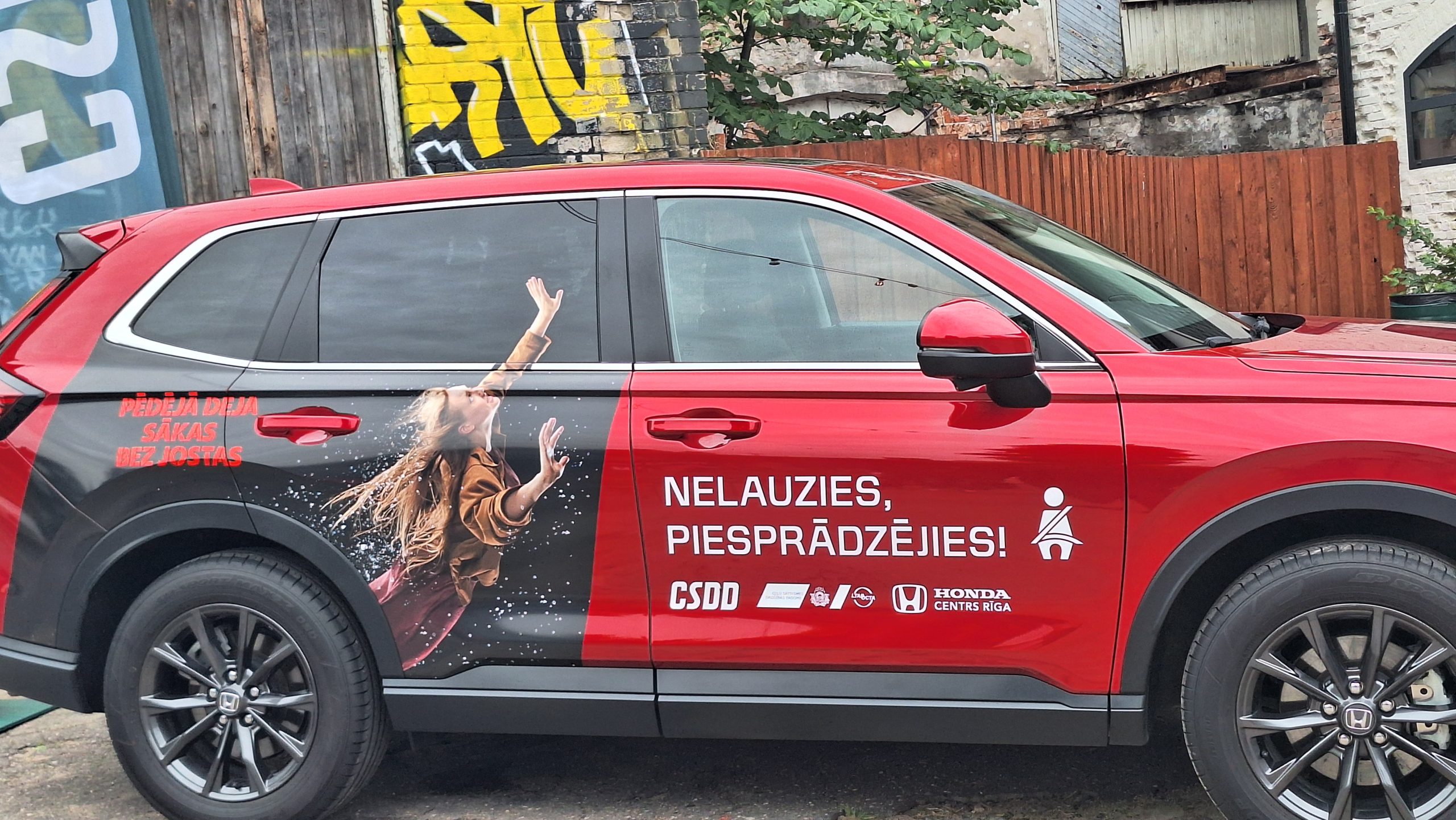 CSDD kampaņas automašīna ar aicinājumu piesprādzēties ar drošības jostu
