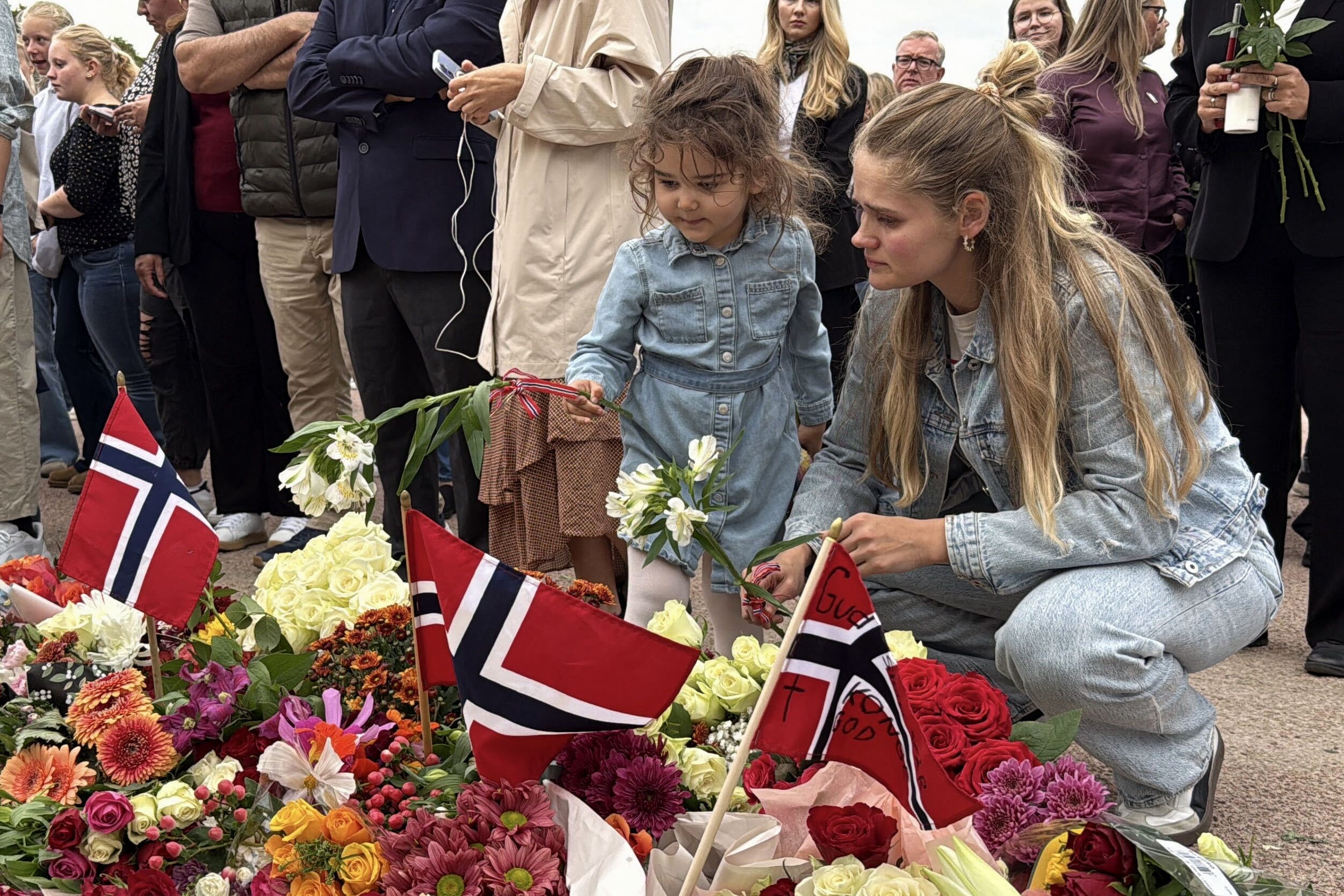 Cilvēki noliek ziedus pie Norvēģijas Karaļa pils Oslo