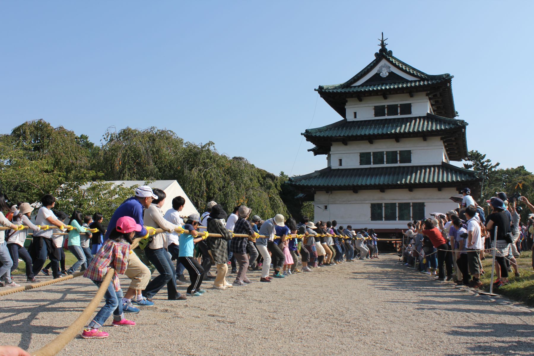 Cilvēki ar virvēm pārvieto Hirosaki pils torni Japānā
