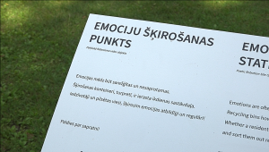 Informatīva plāksne ar uzrakstu "Emociju šķirošanas punkts" Strenču laikmetīgās mākslas izstādē.