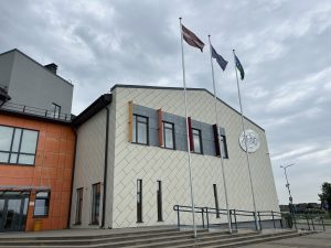 Skolas ēka ar Latvijas, Eiropas Savienības un pašvaldības karogiem