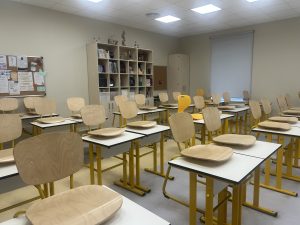 Tukša skolas klase ar skolēnu galdiem un krēsliem