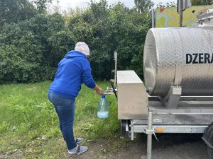 Iedzīvotāja uzpilda dzeramo ūdeni no pārvietojamās ūdens cisternas pēc vētras radītajiem traucējumiem