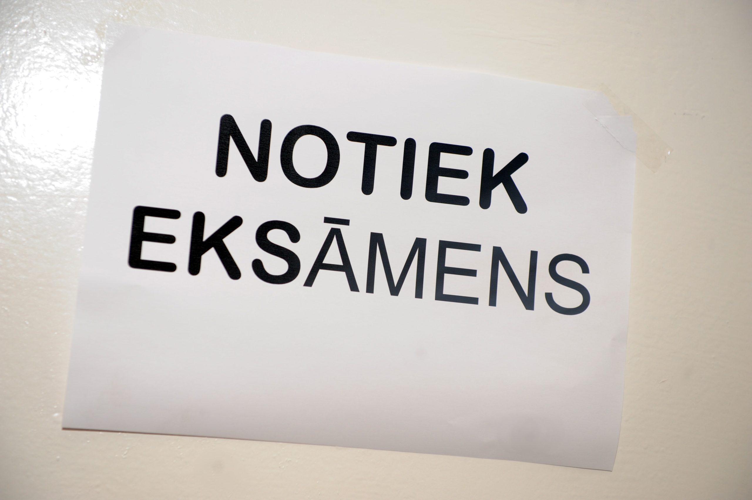 Pie eksāmenu telpas durvīm izvietota zīme “Notiek eksāmens”