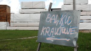 Kokmateriālu ražotnes teritorijā novietotas koka sagataves un norāde “Baļķu krautuve”