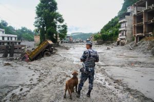 Policists ar dienesta suni plūdu postījumu vietā Nepālā