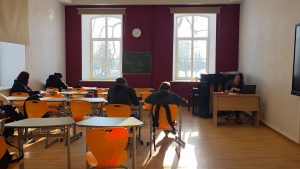Skolēni klasē pie galdiem mācību stundas laikā