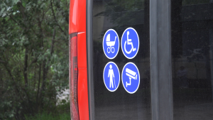 Pieejamības simboli uz Liepājas sabiedriskā transporta mikroautobusa, kas norāda uz vietām cilvēkiem ar invaliditāti un bērnu ratiņiem.
