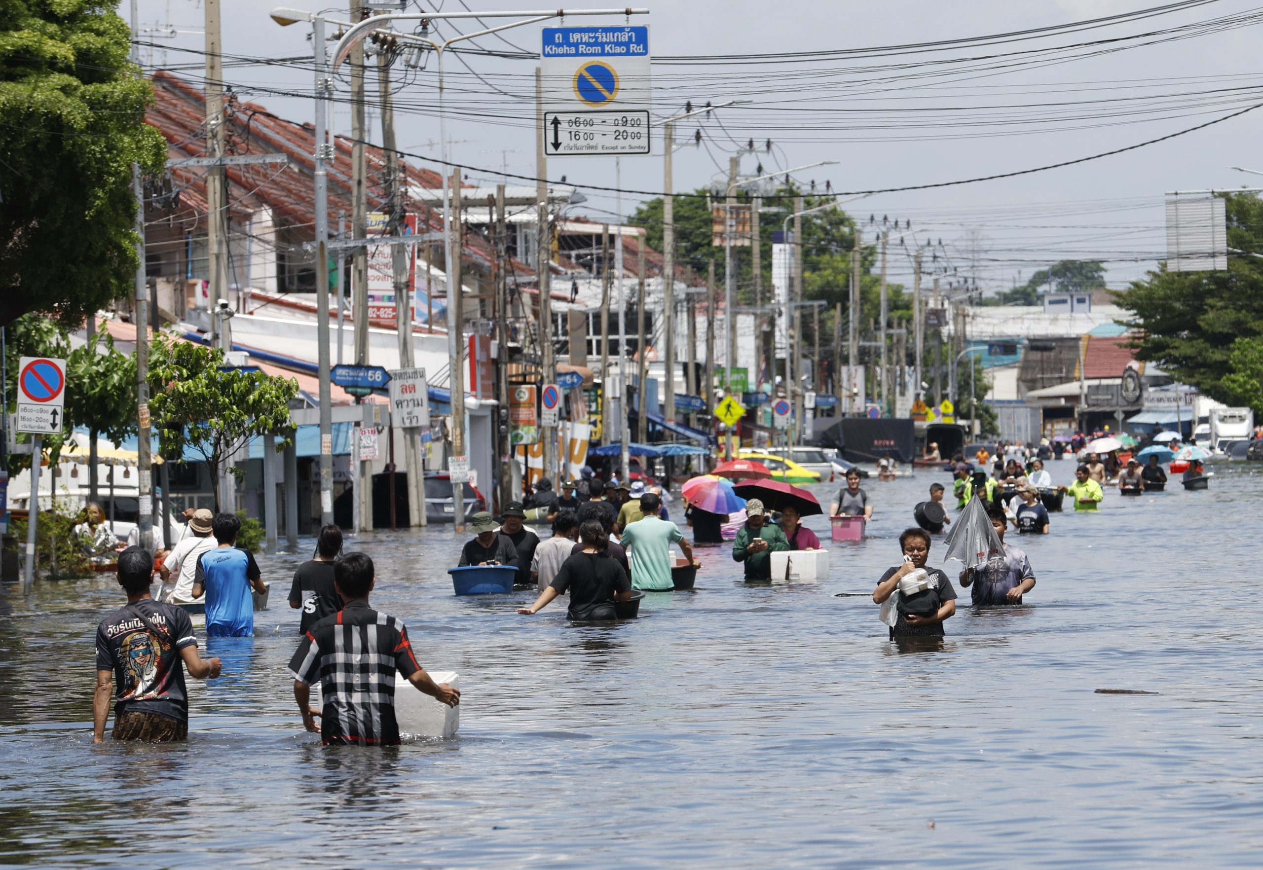 Cilvēki brien pa applūdušu ielu Bangkokā