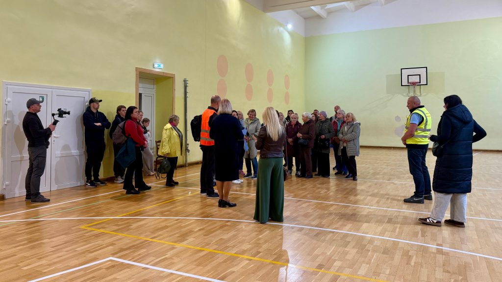 Evakuācijas mācību dalībnieki skolas sporta zālē