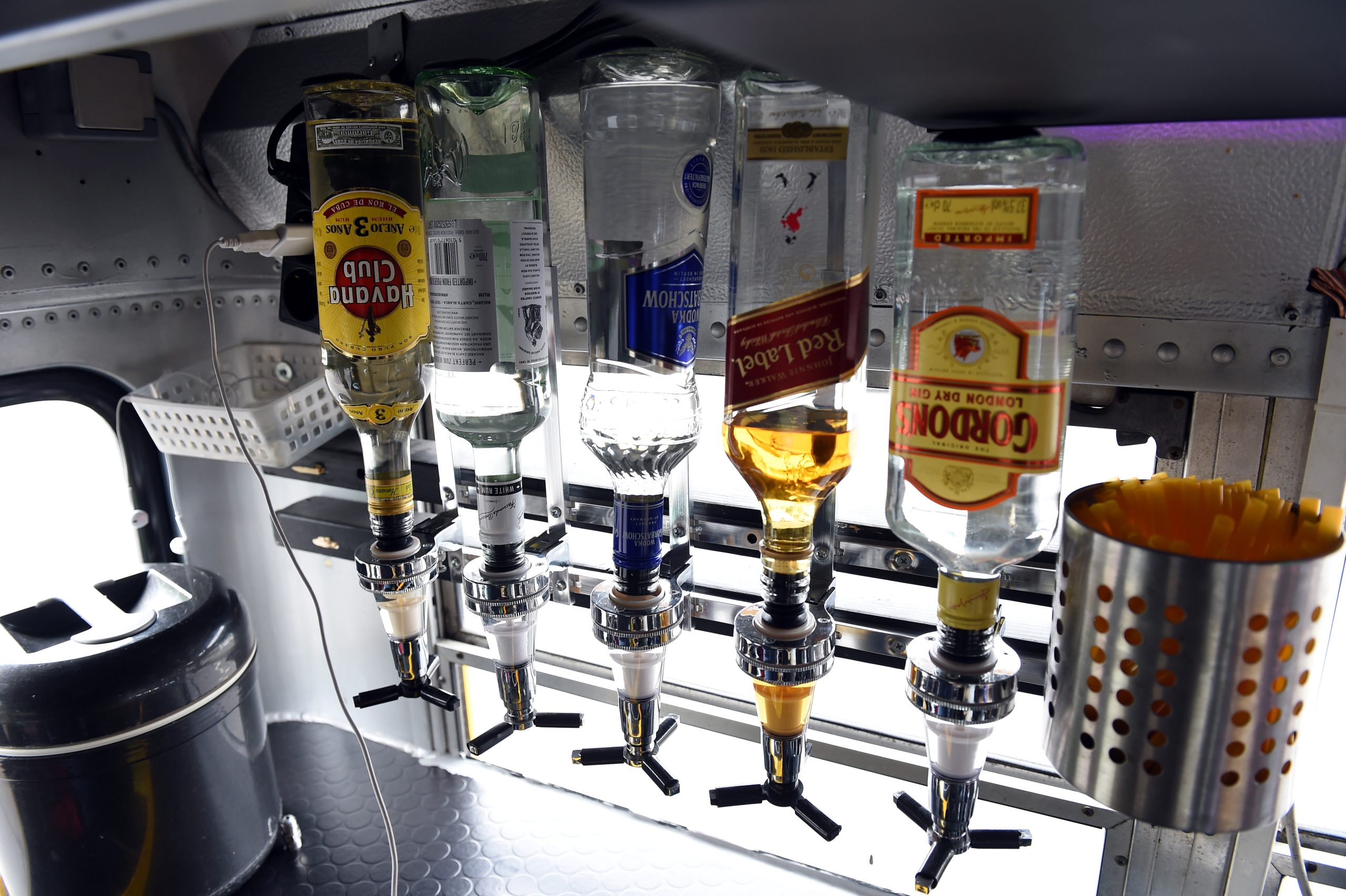 Stiprā alkohola pudeles dzērienu dozatoros publiskās tirdzniecības vietā