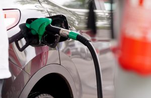 Automašīna degvielas uzpildes stacijā ar ievietotu degvielas pistoli