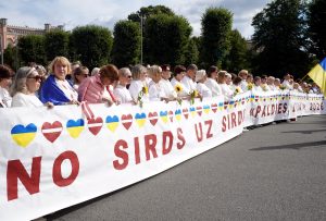 Cilvēki ar Latvijas un Ukrainas simboliku pateicas Latvijai par atbalstu Ukrainai