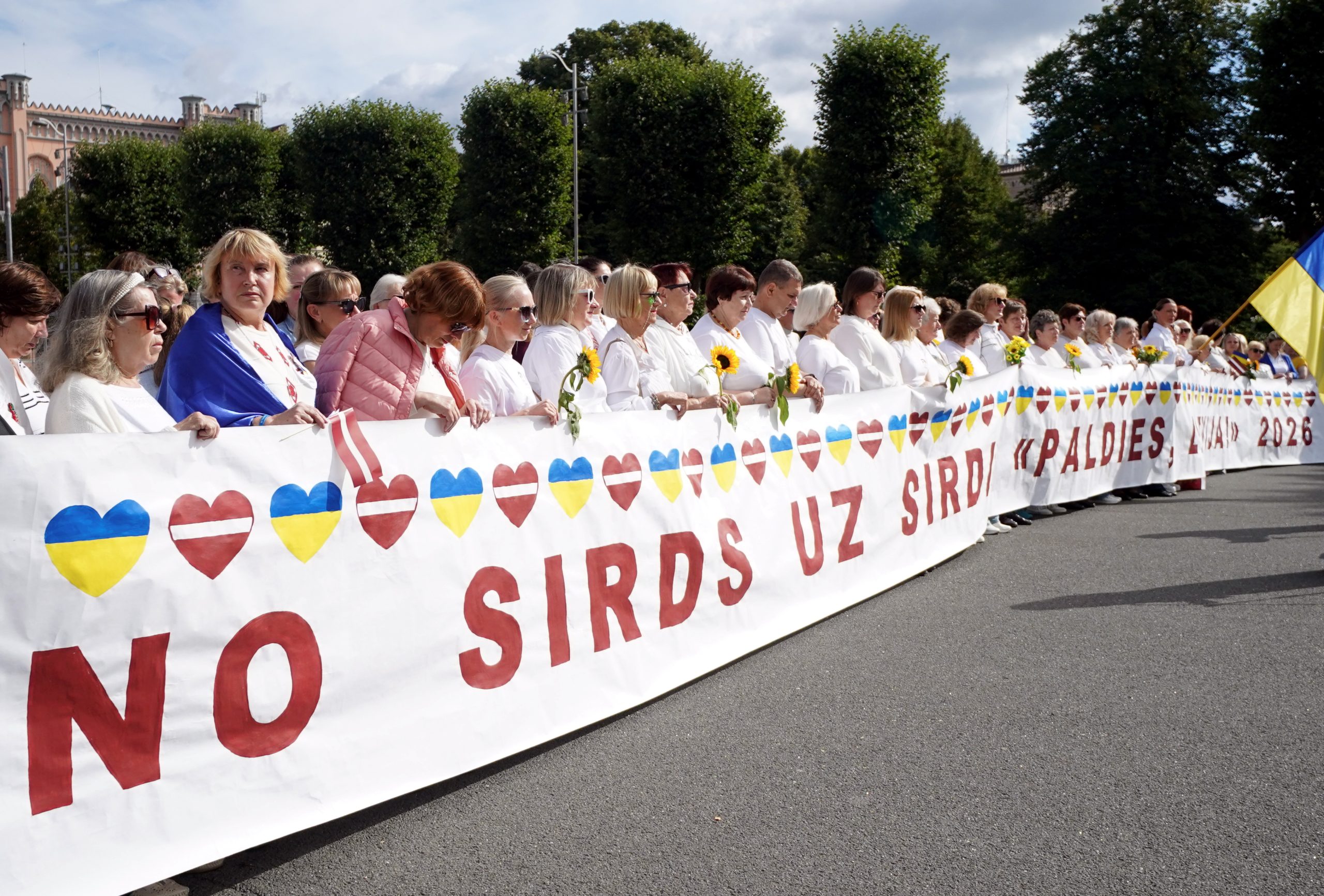 Cilvēki ar Latvijas un Ukrainas simboliku pateicas Latvijai par atbalstu Ukrainai