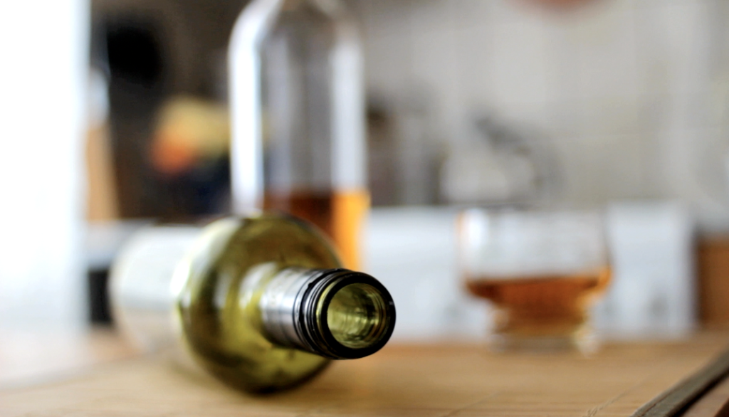 Alkohola pudele un glāzes uz galda