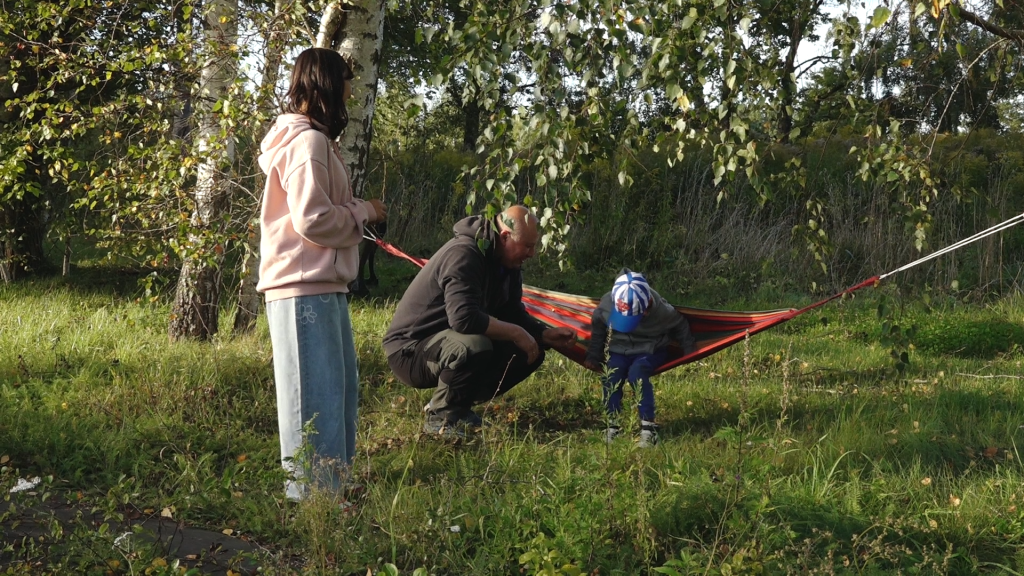 Ģimene pie šūpuļtīkla pagalmā