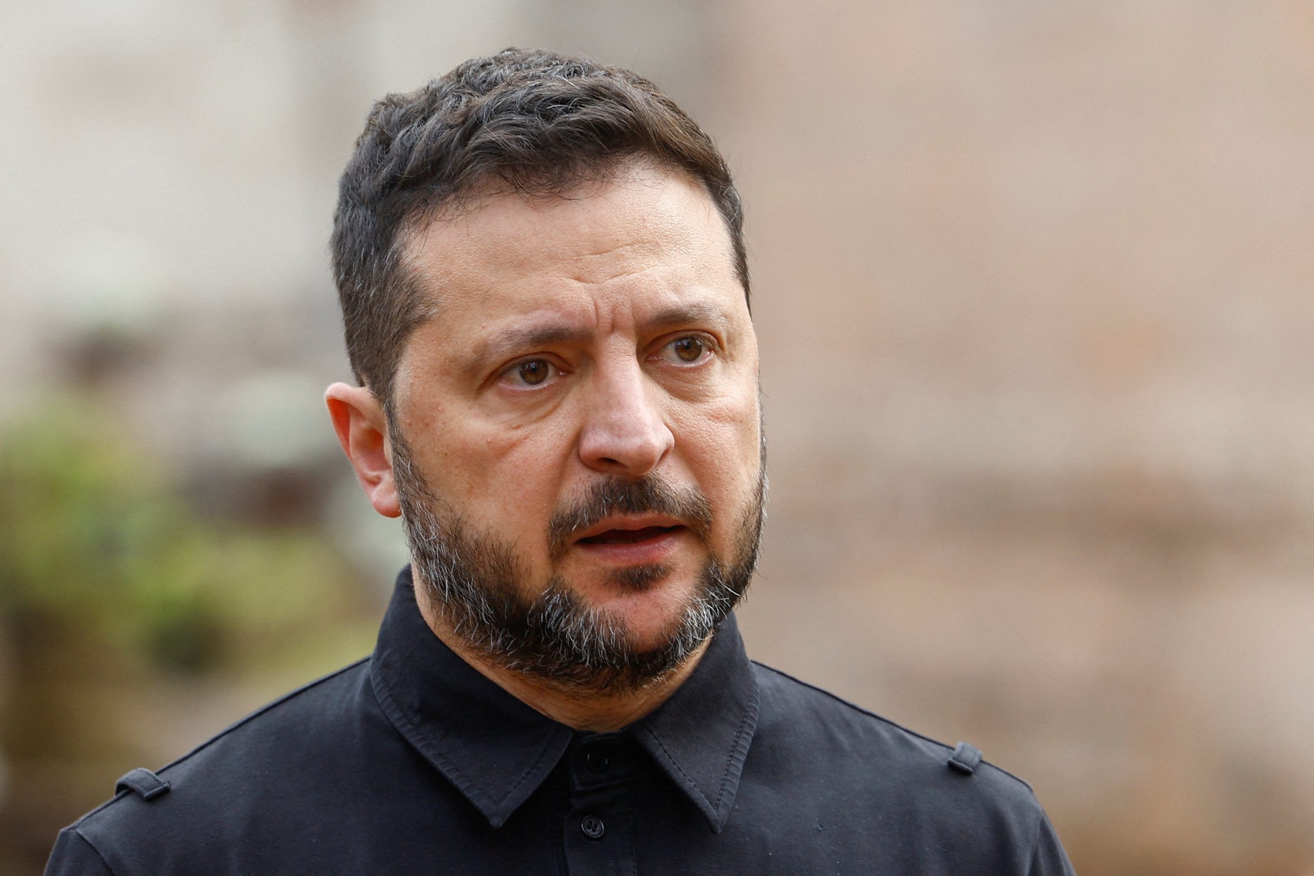 Ukrainas prezidents Volodimirs Zelenskis melnā apģērbā, runājot ar žurnālistiem.